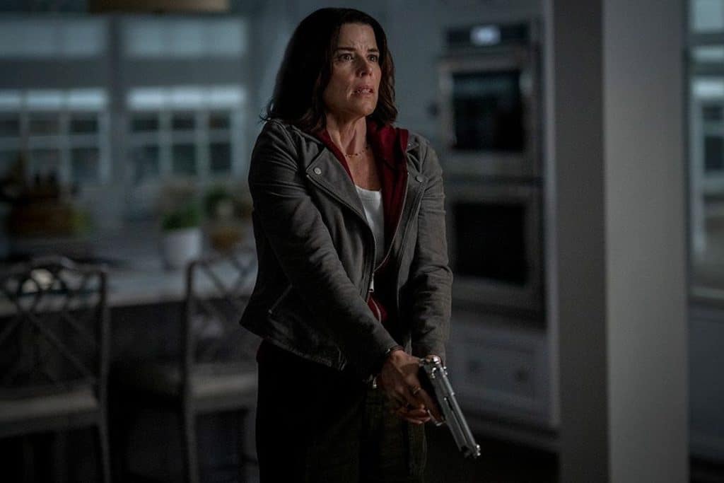 Sidney Evans-Prescott stands scared in her home holding a gun in two hands in Scream 7