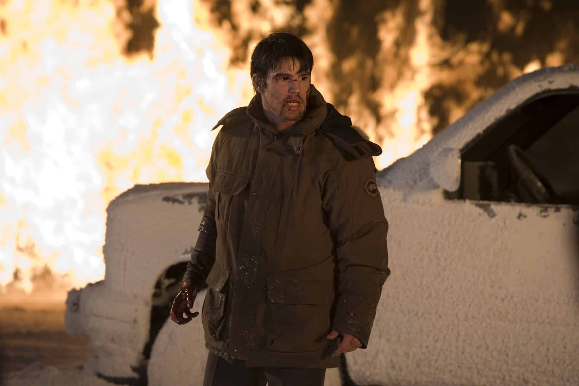 Sheriff Eben stands agains the devastation of a burning car in 30 Days of Night